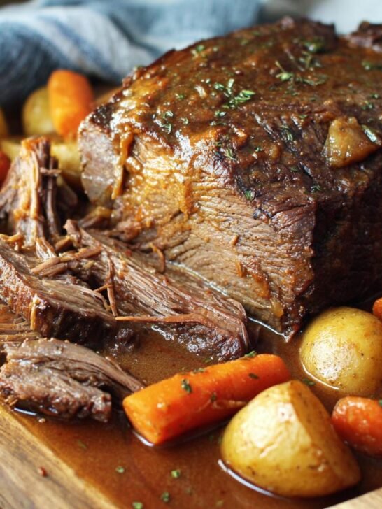 A juicy and tender chuck roast recipe, slow-cooked with carrots and potatoes in a rich gravy.