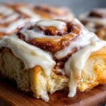 Close-up of a fluffy cinnamon roll with gooey cream cheese frosting, part of a cinnamon roll recipe.