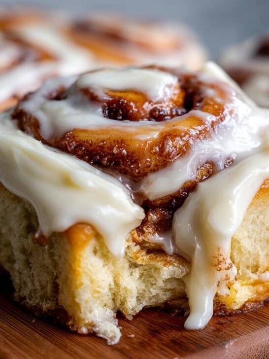 Close-up of a fluffy cinnamon roll with gooey cream cheese frosting, part of a cinnamon roll recipe.