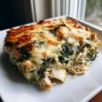A delicious slice of Creamy High Protein Spinach and Artichoke Chicken Casserole, featuring shredded chicken, spinach, and melted cheese.
