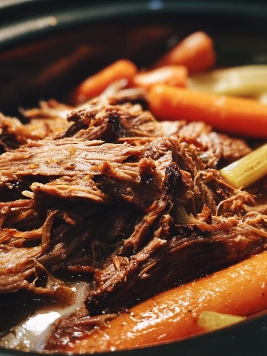 Close-up of shredded beef with carrots and celery in a crock pot, showcasing one of the best crock pot recipes.