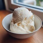 Two scoops of creamy, white Delightful Frozen Yogurt in a light blue bowl.
