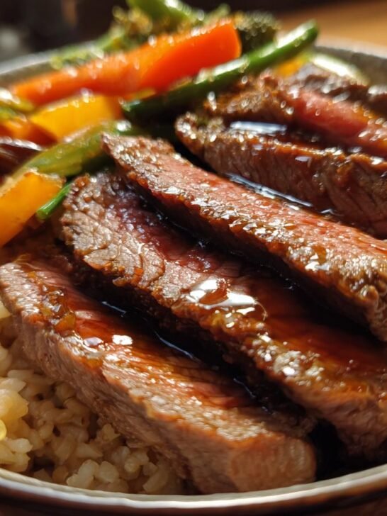 Close-up of a Flavorful Steak Bowl with sliced steak, rice, and colorful vegetables like carrots and bell peppers.