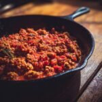 A cast iron skillet filled with a hearty ground turkey and tomato sauce mixture, a delicious example of ground turkey recipes.