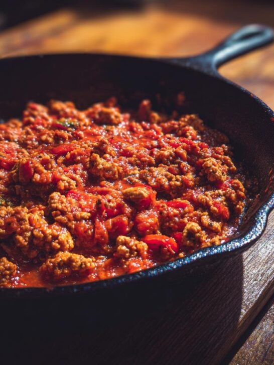 A cast iron skillet filled with a hearty ground turkey and tomato sauce mixture, a delicious example of ground turkey recipes.
