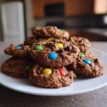A stack of Irresistible Cake Mix Monster Cookies loaded with M&Ms and chocolate chips.