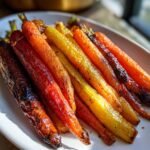 A close-up of a platter of Irresistible Honey Roasted Colorful Carrots, glistening and caramelized.