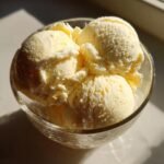 Close-up of creamy vanilla ice cream scoops in a glass bowl, perfect for Ninja Creami recipes.