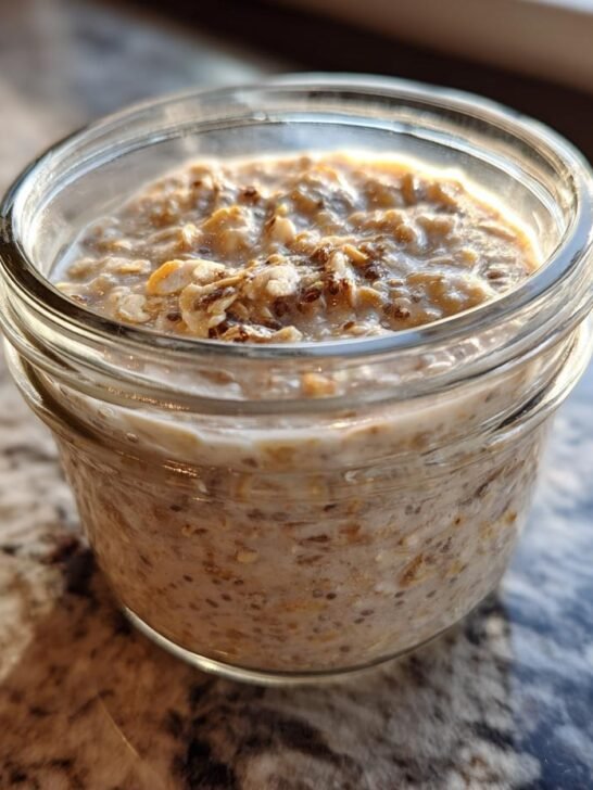 Close-up of a glass jar filled with creamy overnight oats recipe, showing oats, chia seeds, and a hint of cinnamon.