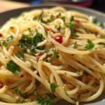 Close-up of spaghetti tossed with garlic, chili flakes, and fresh parsley, a classic example of quick pasta recipes.