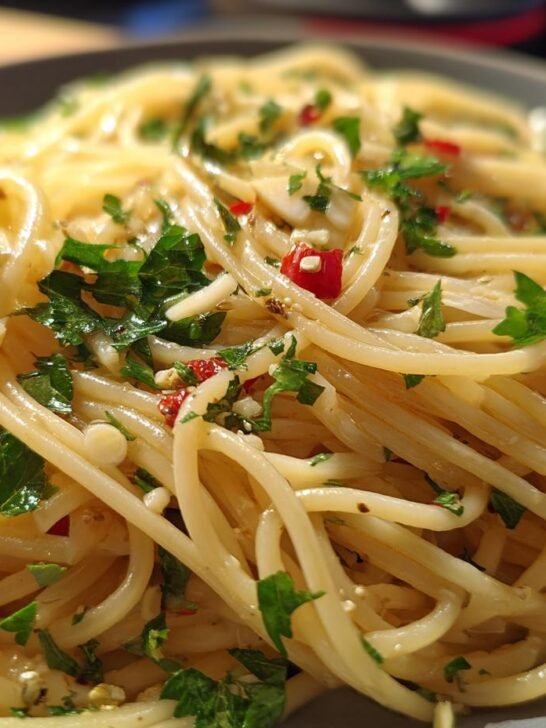 Close-up of spaghetti tossed with garlic, chili flakes, and fresh parsley, a classic example of quick pasta recipes.