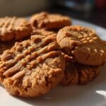 Close-up of a stack of freshly baked peanut butter cookies with classic fork marks.