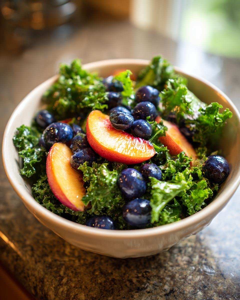 Close-up of a refreshing summer peach and blueberry kale salad in a bowl, showcasing vibrant colors and fresh ingredients.