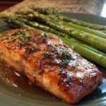 A perfectly cooked salmon fillet with herbs and spices, served alongside roasted asparagus spears, ideal for easy dinner recipes.