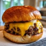 A close-up of a delicious smash burger recipe with melted cheese and a toasted bun.