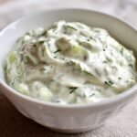 A bowl of creamy homemade tartar sauce recipe with chopped dill pickles and fresh herbs.