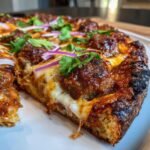 A close-up, cheesy slice of Best Texas BBQ Sriracha Meatball Pizza topped with glazed meatballs, red onion, and cilantro.