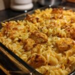 Close-up of Irresistible Cajun Cream Cheese Chicken Pasta Bake, featuring rotini pasta, seasoned chicken pieces, and melted cheese.