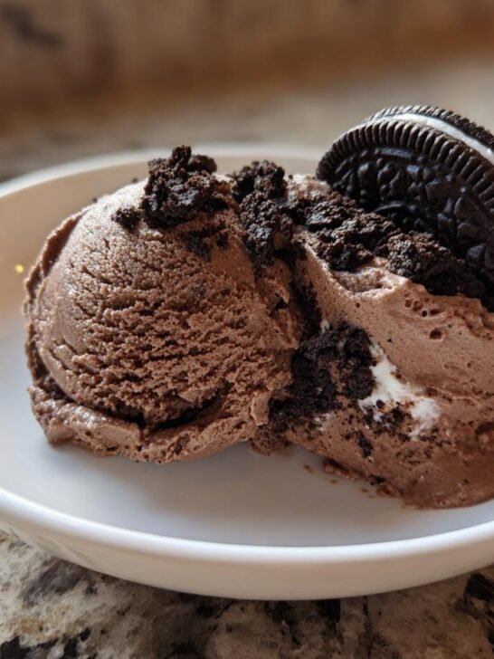 Two scoops of rich Chocolate Oreo Ice Cream No Churn topped with crushed cookies and a whole Oreo.