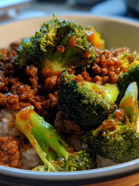 A close-up of a bowl filled with white rice, topped with flavorful ground beef and broccoli stir fry.