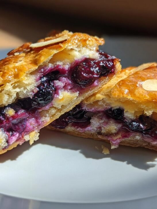 Close-up of a Homemade Wild Blueberry Almond Pop Tart, cut in half, revealing a rich blueberry filling and flaky pastry.