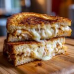 Close-up of an Irresistible Cheesy Chicken Garlic Bread Sandwich, stacked and oozing with melted cheese.