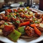A close-up of Irresistible Chicken Stir Fry With Vegetables, featuring tender chicken pieces and colorful bell peppers, onions, and carrots in a glossy sauce.