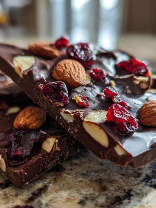 Close-up of irresistible chocolate bark recipes, featuring dark chocolate with whole almonds and dried cranberries.