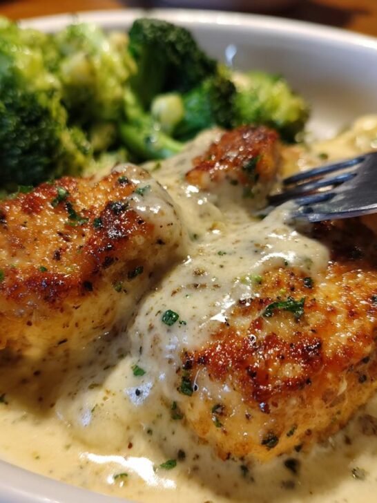 Close-up of irresistible low carb chicken pieces in a creamy sauce, served with steamed broccoli.