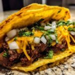 A close-up of an Irresistible Smash Burger Taco loaded with seasoned beef, melted cheese, diced onions, and fresh cilantro.