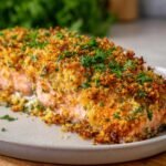 Close-up of Irresistible Stuffed Salmon with a golden-brown breadcrumb crust and fresh parsley.