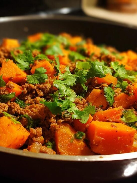 Close-up of an Irresistible Turkey Sweet Potato Skillet, featuring cubed sweet potatoes and ground turkey, garnished with fresh cilantro.