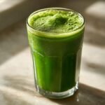 A tall glass filled with vibrant green Morning Glory Detox Juice, topped with a frothy layer.