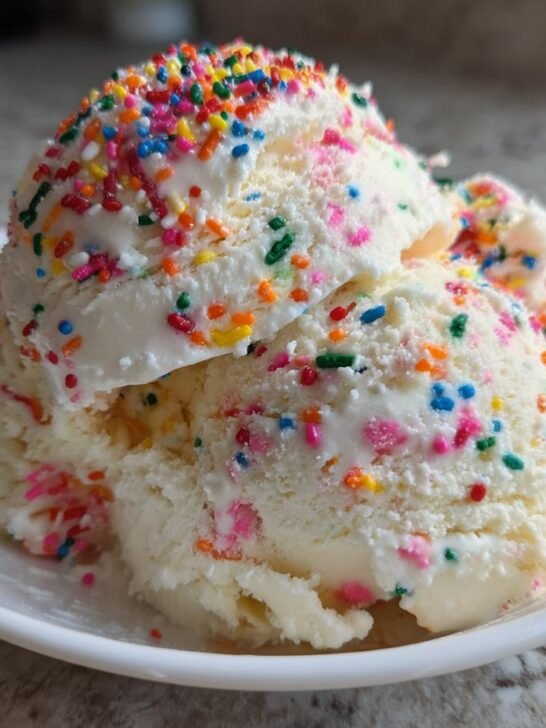 Two generous scoops of creamy No Churn Vanilla Ice Cream Rainbow Sprinkles in a white bowl.