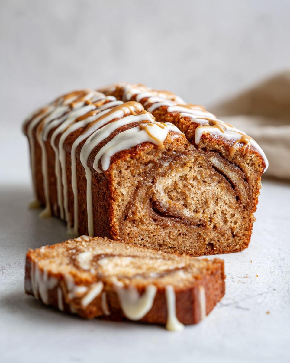 A slice of One Layer Banana Biscoff Cake with a swirl pattern and white chocolate drizzle.