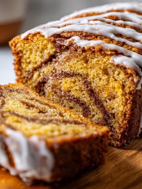 A close-up of a sliced One Layer Banana Biscoff Cake with a white glaze drizzled on top.
