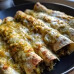 Close-up of several Skillet Meatless Enchiladas With Salsa Verde topped with melted white cheese.