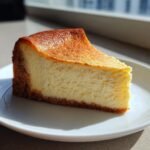 A perfect slice of Not So Classic New York Style Cheesecake with a golden brown top and thick graham cracker crust.