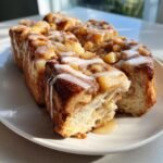 Close-up of warm Vegan Apple Cinnamon Pull Apart Bread drizzled with white icing and apple filling.