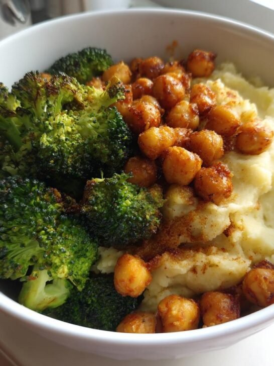 A white bowl filled with Vegan Chickpea Broccoli Mashed Potato Bowl, featuring creamy mash, roasted broccoli, and spiced chickpeas.
