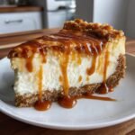 A decadent slice of the Best Caramel Apple Spice Cheesecake with thick caramel dripping down the sides.