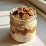 Close-up of Biscoff Cookie Overnight Oats layered with cookie butter and topped with crushed Biscoff cookies.