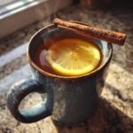 A steaming Bourbon Maple Hot Toddy Mocktail in a blue ceramic mug, garnished with a lemon slice and cinnamon stick.