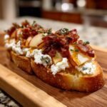 Two slices of Fall Harvest Apple Bacon Crostini topped with cheese, apple slices, bacon, and thyme.