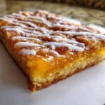 Close-up of a square slice featuring thick Giant Pop Tart Orange Filling and a white icing drizzle.