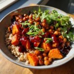 A vibrant Gochujang Sweet Potato Chickpea Bowl served over brown rice, topped with glossy sauce and green onions.