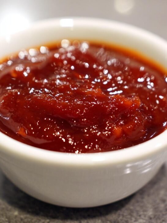 Close-up shot of thick, glossy, deep red My Favorite Gochujang Sauce served in a small white dipping bowl.