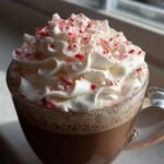 Close-up of a rich Peppermint White Chocolate Mocha topped with whipped cream and crushed candy canes.