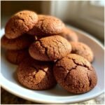 A close-up stack of freshly baked Soft Chewy Christmas Gingerbread Cookies, coated in sugar and showing cracked tops.