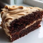 Close-up of a rich, dark slice of Vegan Gingerbread Cake Chai Buttercream frosting.